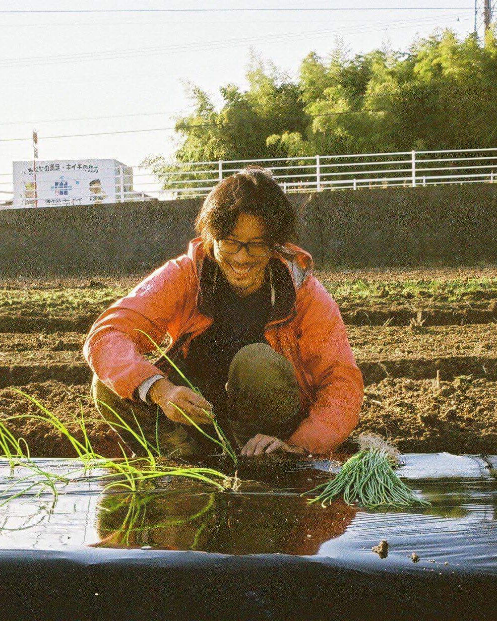 畑で苗を植える松井さん（移住したてのころ）